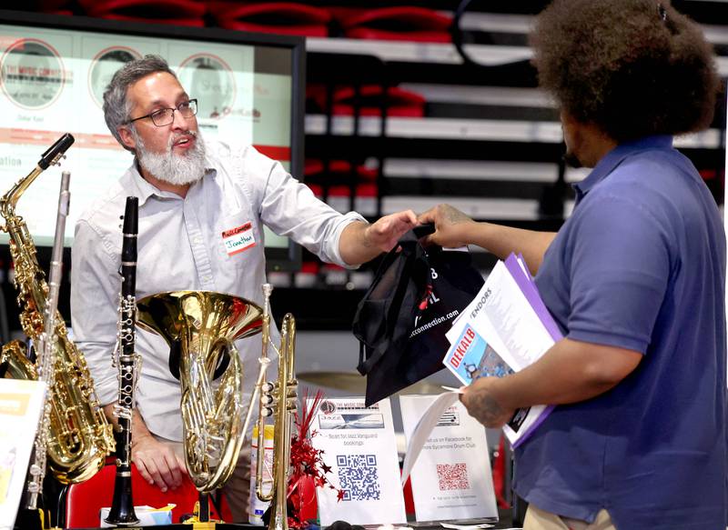 Jonathan Dixit, a bass instructor, talks to a visitor at The Music Connection booth Thursday, April 24, 2025, during the Local Showcase and Spring Show in the Convocation Center at Northern Illinois University in DeKalb.