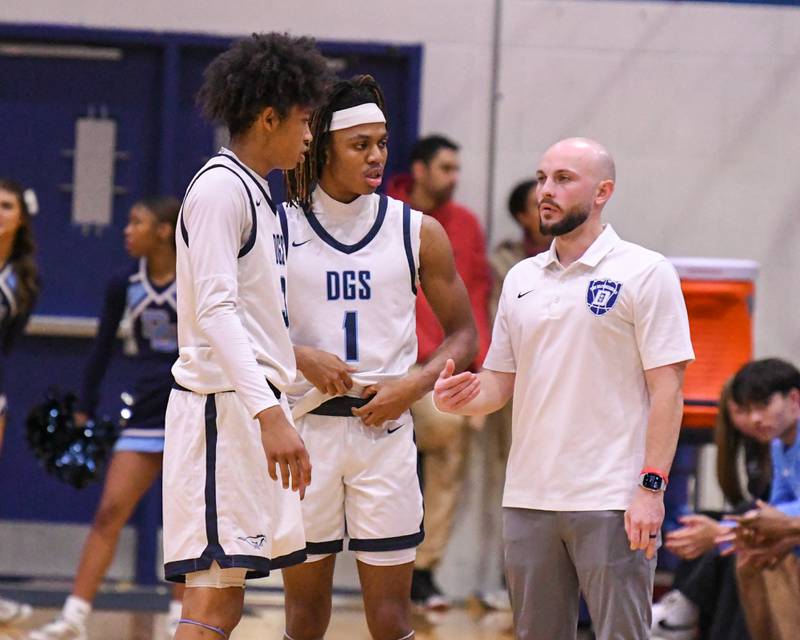 Downers Grove South's head coach Zachary Miller talks to Downers Grove South's Adam Flowers, left, and Downers Grove South's Keon Maggitt during a break in the action on Saturday Dec. 21, 2024, while taking on Downers Grove South held at Downers Grove South High School.
