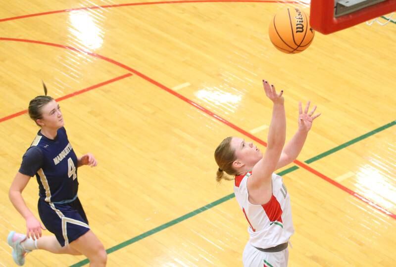 L-P's Elizabeth Sines lets go of a shot underneath the hoop on a break away as Marquette's Hunter Hopkins trails behind