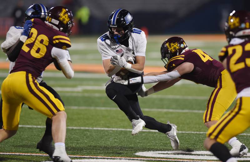 Lincoln-Way East's Cade Serauskis carries the balll as Loyola Academy's Emmett McCarthy (41) tries to make the tackle during the Class 8A football state title game at Memorial Stadium in Champaign on Saturday, Nov. 26, 2022.
