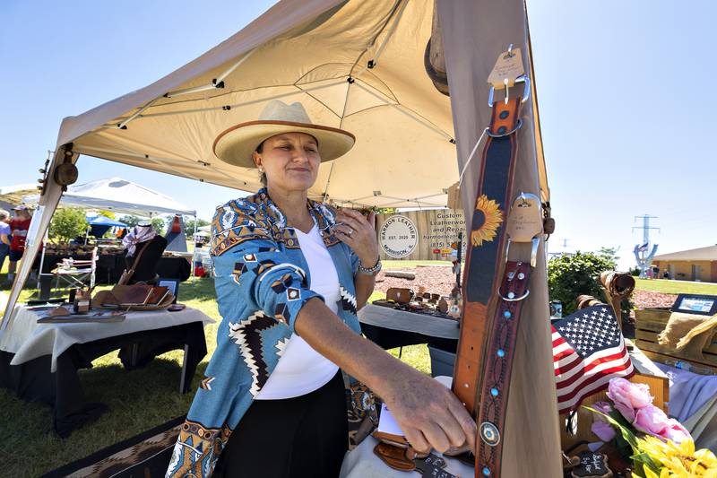 Leather crafter Michelle Harmon of Morrison talks about her work Saturday, August 23, 2025, in Rock Falls. Harmon had her pieces on display at a booth during the Art in the Park sculpture walk.