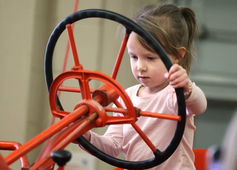 Adelene Baumann, 4, pretends to drive a tractor Wednesday, Feb. 19, 2025, during the DeKalb High School Future Farmers of America Barnyard Zoo Family Night at the school.