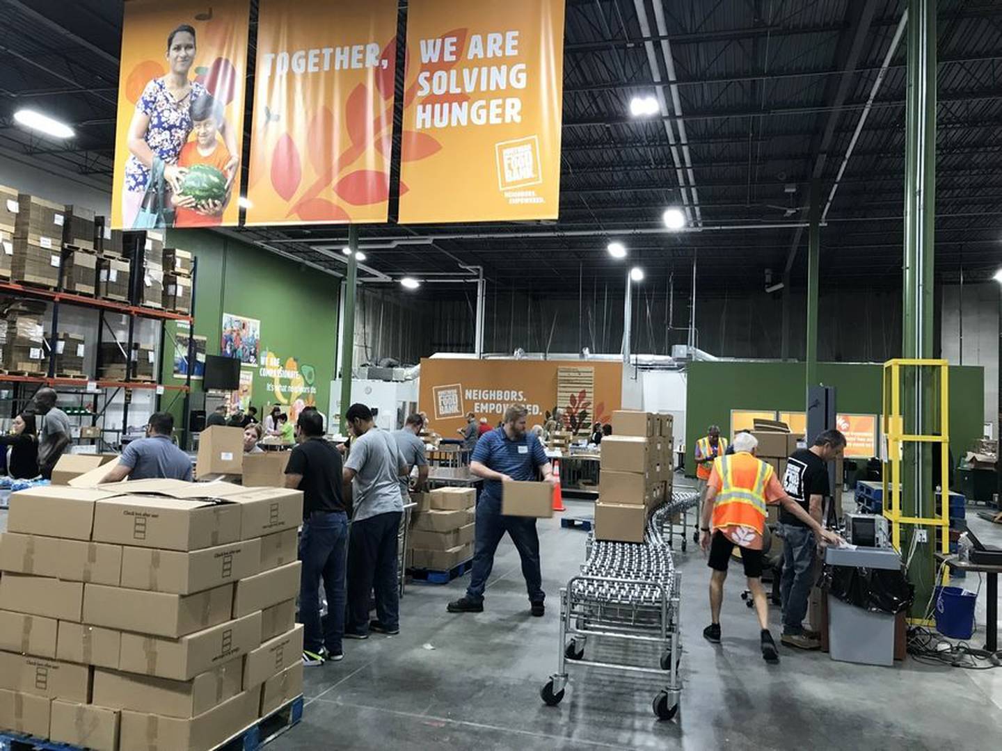 The Northern Illinois Food Bank's distribution center is abuzz with activity Wednesday, Aug. 16, 2023, as volunteers inspect and package food. The relocated and expanded center, which serves Lake and McHenry counties, opened a year ago.