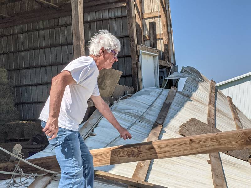 Valley View Farm owner Bruce Grider looks at a hay barn wall that was severely damaged in the tornado that tore through the area Monday.