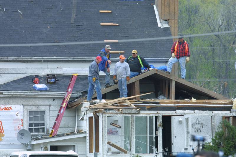 Crews work on fixing a roof on a home that was damaged by the tornado in April 2004 downtown Utica.