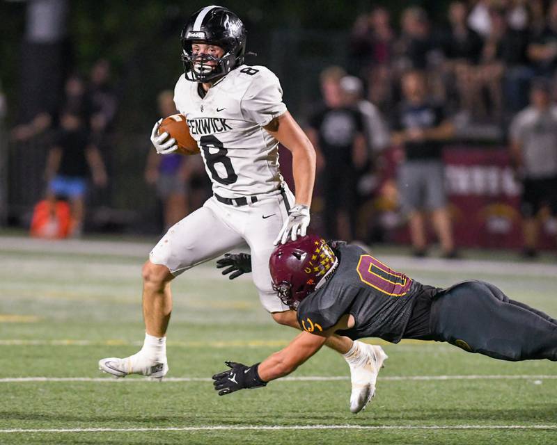 Fenwick's Jake Thies (8) gains a few extra yards after getting tripped up by Montini Catholic’s Laddie Asay (0) during the game on Friday Sept. 19, 2025, held at Montini Catholic High School.