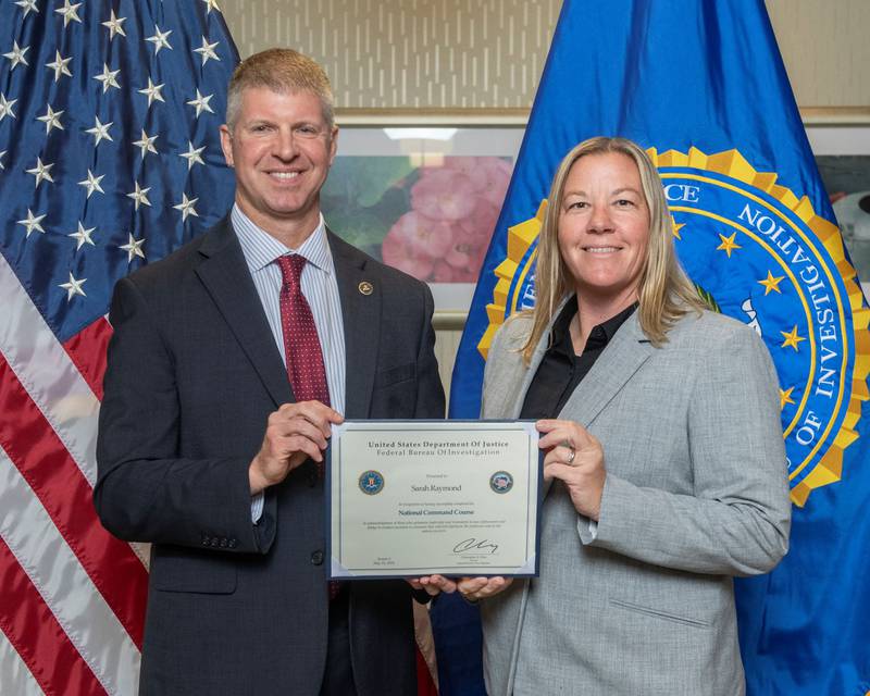 Peru Police Chief Sarah Raymond is awarded a certificate of completion of the FBI National Command Course from FBI Section Chief, Leadership & Training Services Section, Todd Bobe.