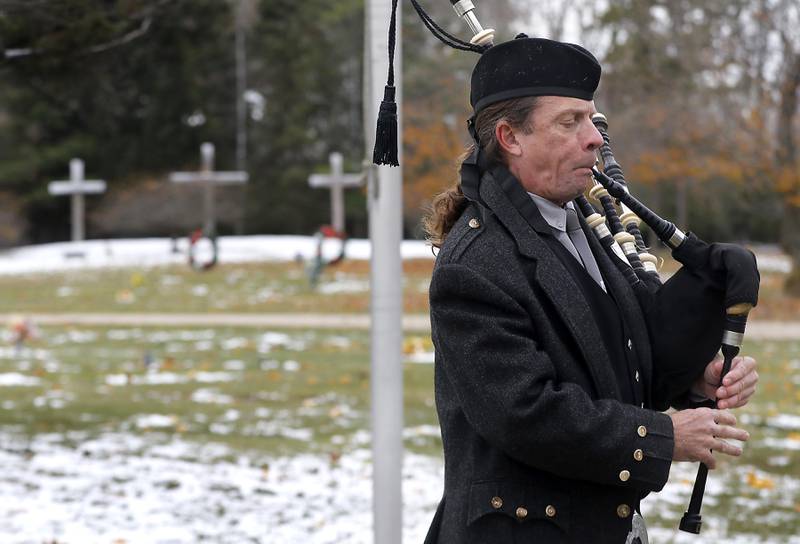 Tim Hess, of the Dundee Scottish Pipes, plays “Taps” during the Veterans Day flag placement ceremony Tuesday, Nov. 11, 2025, at the gravesites of veterans at McHenry County Memorial Park Cemetery in Woodstock. Members of the Knights of Columbus Patriotic 4th Degree from the Bishop Boylan Assembly placed American Flags at nearly 140 veterans' grave markers.
