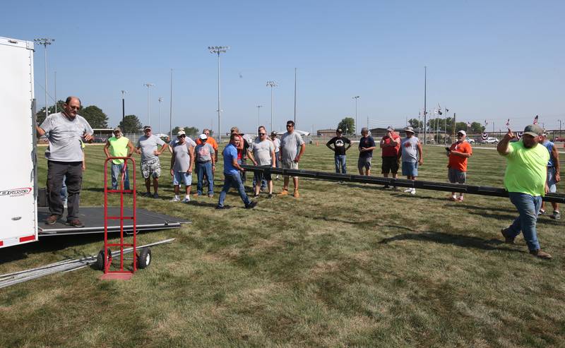 Around 50 volunteers carry materials to help set up the Vietnam Traveling Memorial Wall on Thursday, Aug. 24 at Veterans Park in Peru.