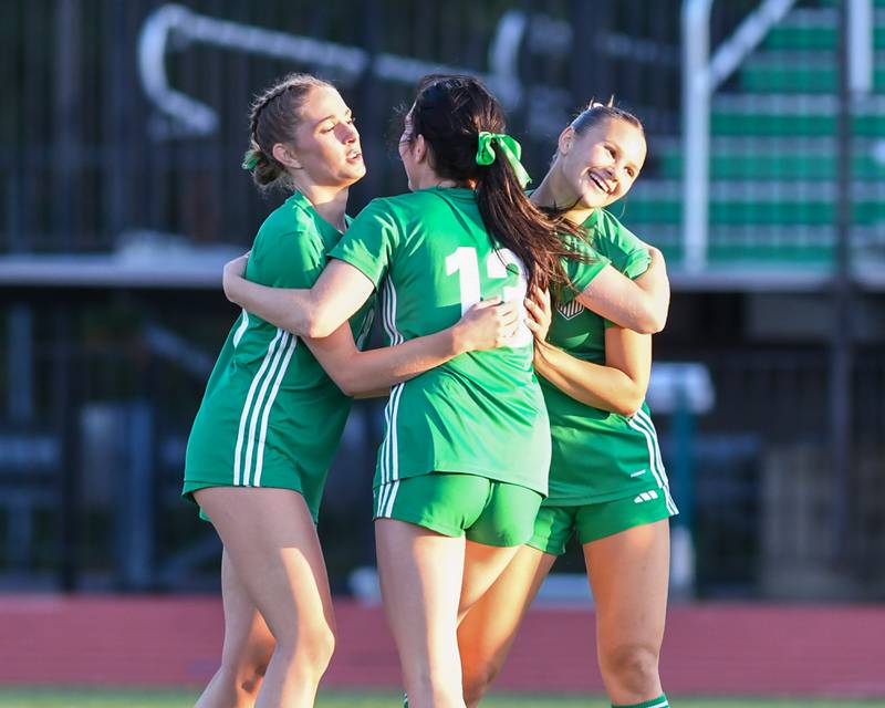 York's Cate Carter, right, is all smiles as she gets a congratulation hug from teammates Jordan Ebner, center), and Maggie Quinn during the regional title game on Friday May 23, 2025, while taking on Downers Grove South held at York High School.