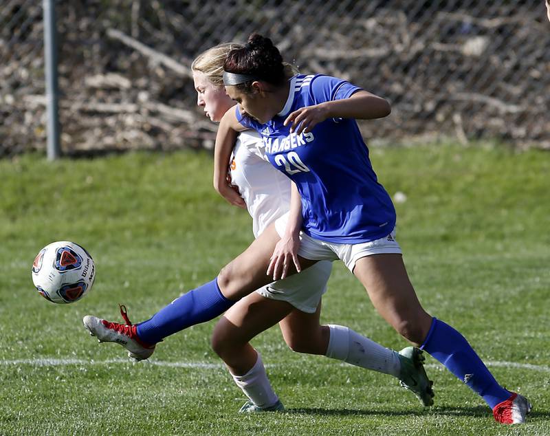 Crystal Lake Central's Olivia Anderson kicks the ball as Dundee-Crown's Giselle Farias grabs her during a Fox Valley Conference soccer match Tuesday April 26, 2022, between Crystal Lake Central and Dundee-Crown at Dundee-Crown High School.