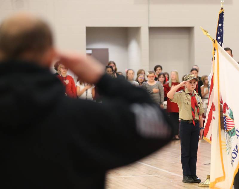 Boy Scout Joanny Michael of Cherry Troop 1055, salutes the American Flag as a Veteran salutes in foreground during the presentation of the flag at the Veterans Day Program at Parkside School on Friday, Nov. 11, 2022 in Peru.
