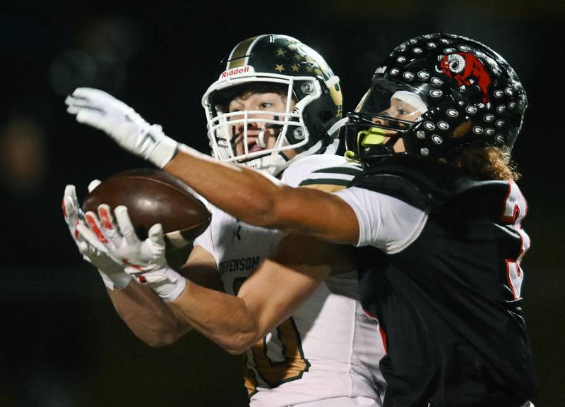 Stevenson’s Thomas Simmons catches a pass ahead of Glenbard East’s Chris Renford during the Class 8A second-round football playoff game on Friday, Nov. 8, 2024 in Lombard.