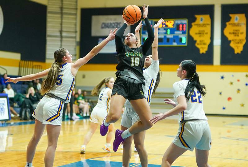 Waubonsie Valley's Danyella Mporokoso (10) shoots the ball in the post against Aurora Central Catholic's Grace Grunloh (5) and Brooklyn Murphy (22) during a basketball game at Aurora Central Catholic High School on Thursday, January 30, 2025.