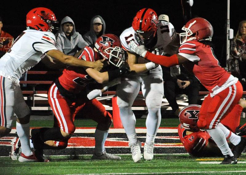 After mishandling the snap on a punt, Bolingbrook's Joey Bodell (11) gets mobbed near the goal line by Yorkville defenders on Friday, Sept. 27, 2024, during a varsity game at Yorkville High School.