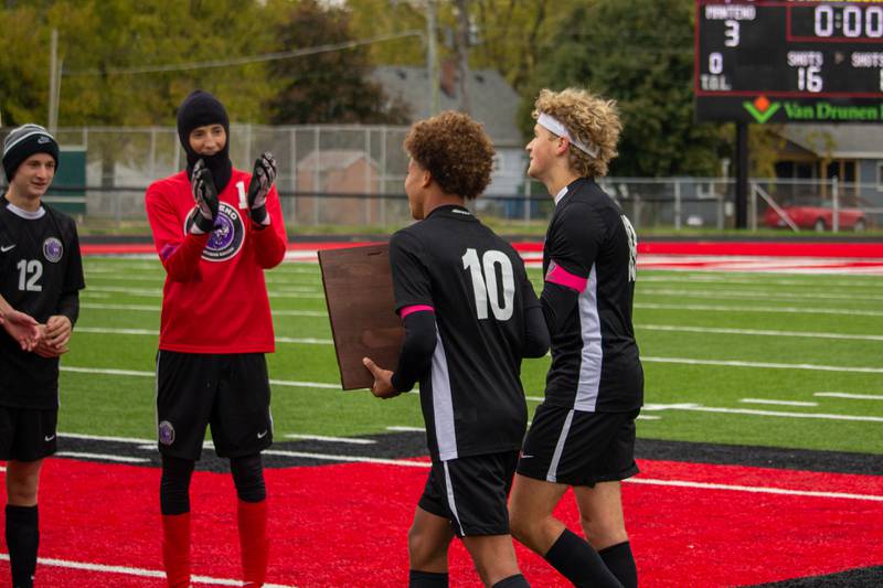 Manteno captains bring the Class 1A Momence Regional championship plaque to their team following Manteno's 3-0 victory over Reed-Custer on Saturday, Oct. 25, 2025.