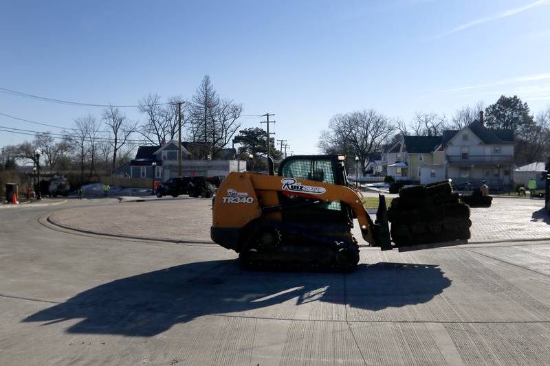 Sod is moved as workers put the finishing touches on the Woodstock roundabout at intersection of Lake Avenue and South and Madison streets on Tuesday Nov. 22, 2022. Construction on the roundabout near Woodstock's downtown is expected to wrap up this week, opening traffic and marking the end of several months of construction. The roundabout has been in the works for several years and was built out this year.