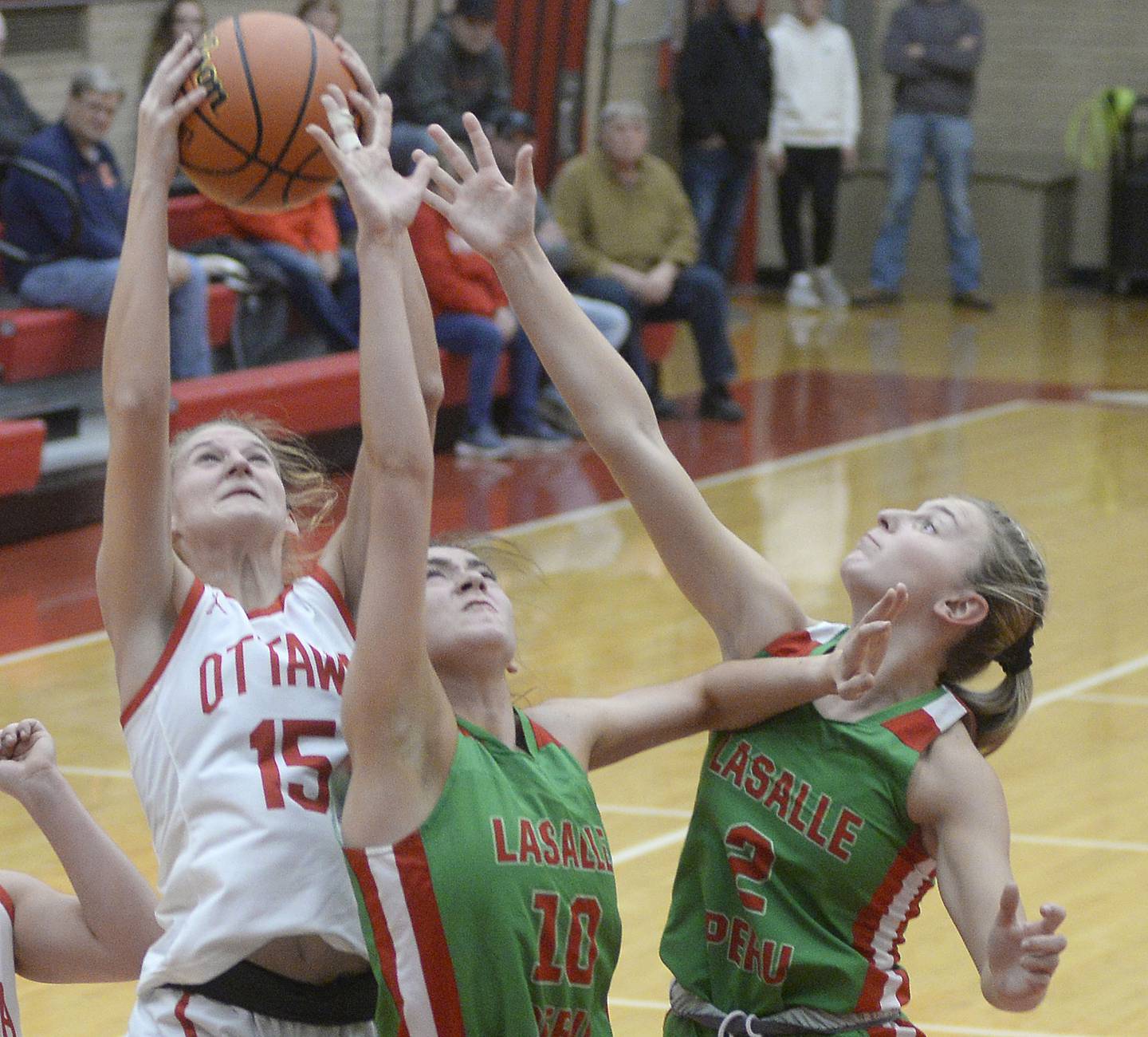 Ottawa’s Hailey Larsen pulls down this rebound ahead of LaSalle Peru’s Bailey Pode and Taylor Martyn in the 1st period on Wednesday Dec. 7, 2022 at Kingman Gymnasium in Ottawa.
