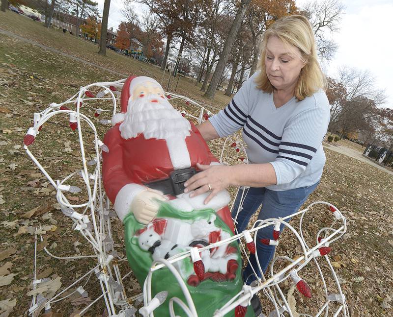 Wanda Schmitt assembles a Santa Claus display as Light Up Streator volunteers added a holiday touch to the Mistletoe Market  at City Park Saturday .