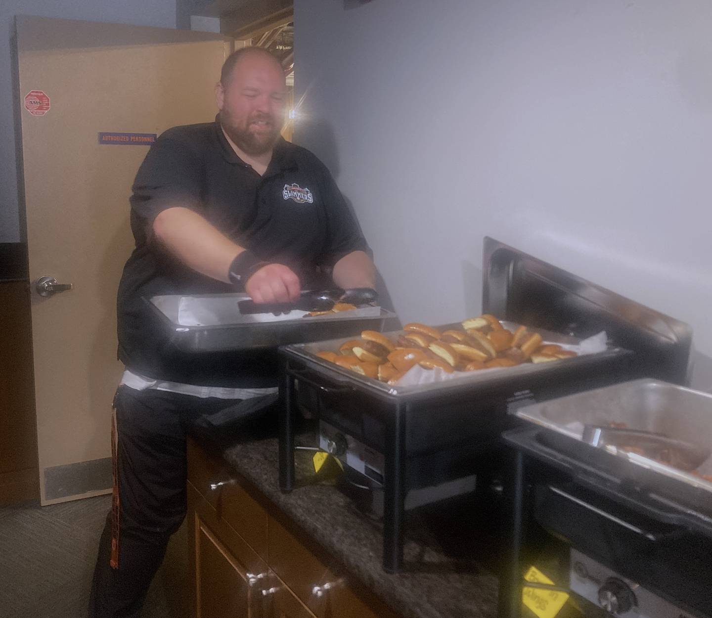 Joel Sigel, food and beverage director for the Joliet Slammers baseball operations, gets ready to bring out a tray of burgers at the team's season preview event at the stadium on Thursday, May 1, 2025.