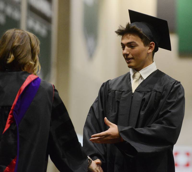 Joe Lewnard/jlewnard@dailyherald.com
A graduate receives his diploma during the Wheaton Warrenville South High School graduation, held at the College of Dupage in Glen Ellyn Saturday.