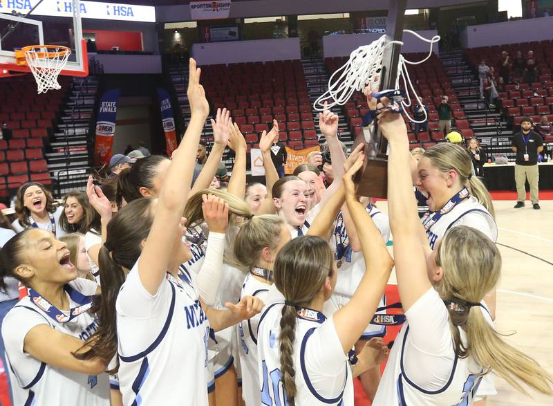 Members of the Nazareth girls basketball team hoist the Class 4A State girls basketball championship trophy after defeating Loyola on Saturday, March 7, 2026 at CEFCU Arena in Normal.