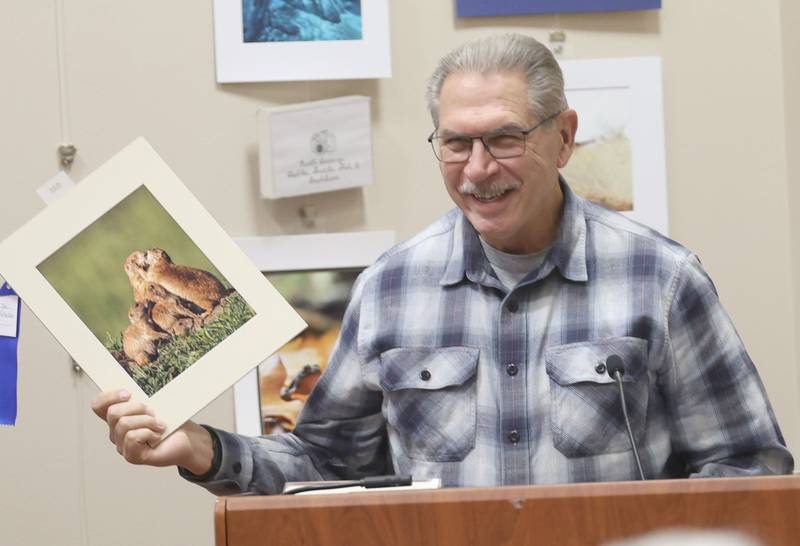 Joe Virbickis of Washington, smiles while holding his first place photo of prairie dogs kissing taken in Custer State Park in South Dakota during the Starved Rock Photography Show awards on Saturday, Jan. 3, 2026 at the Starved Rock Visitors Center.