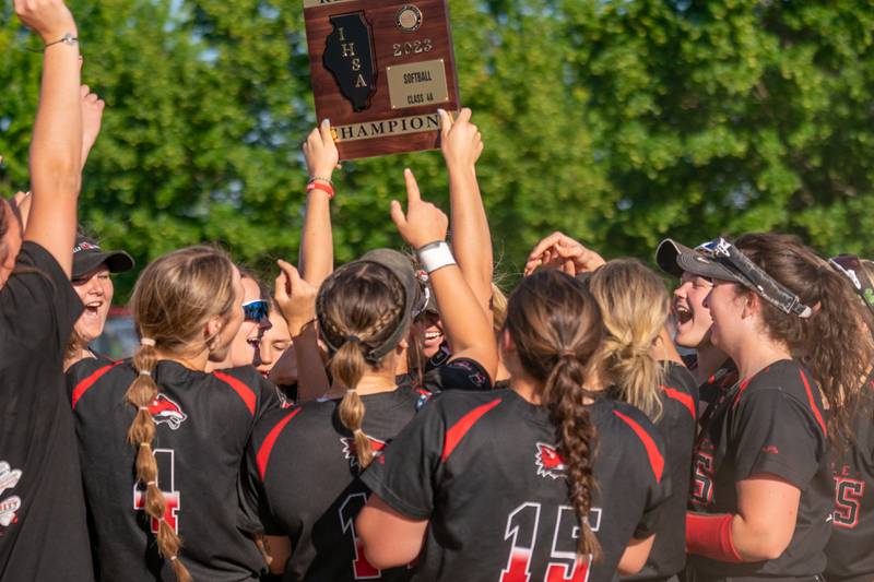 Yorkville softball players raise the 4A regional championship plaque after defeating Plainfield North for the class 4A regional championship at Yorkville High School on Friday, May 26, 2023.