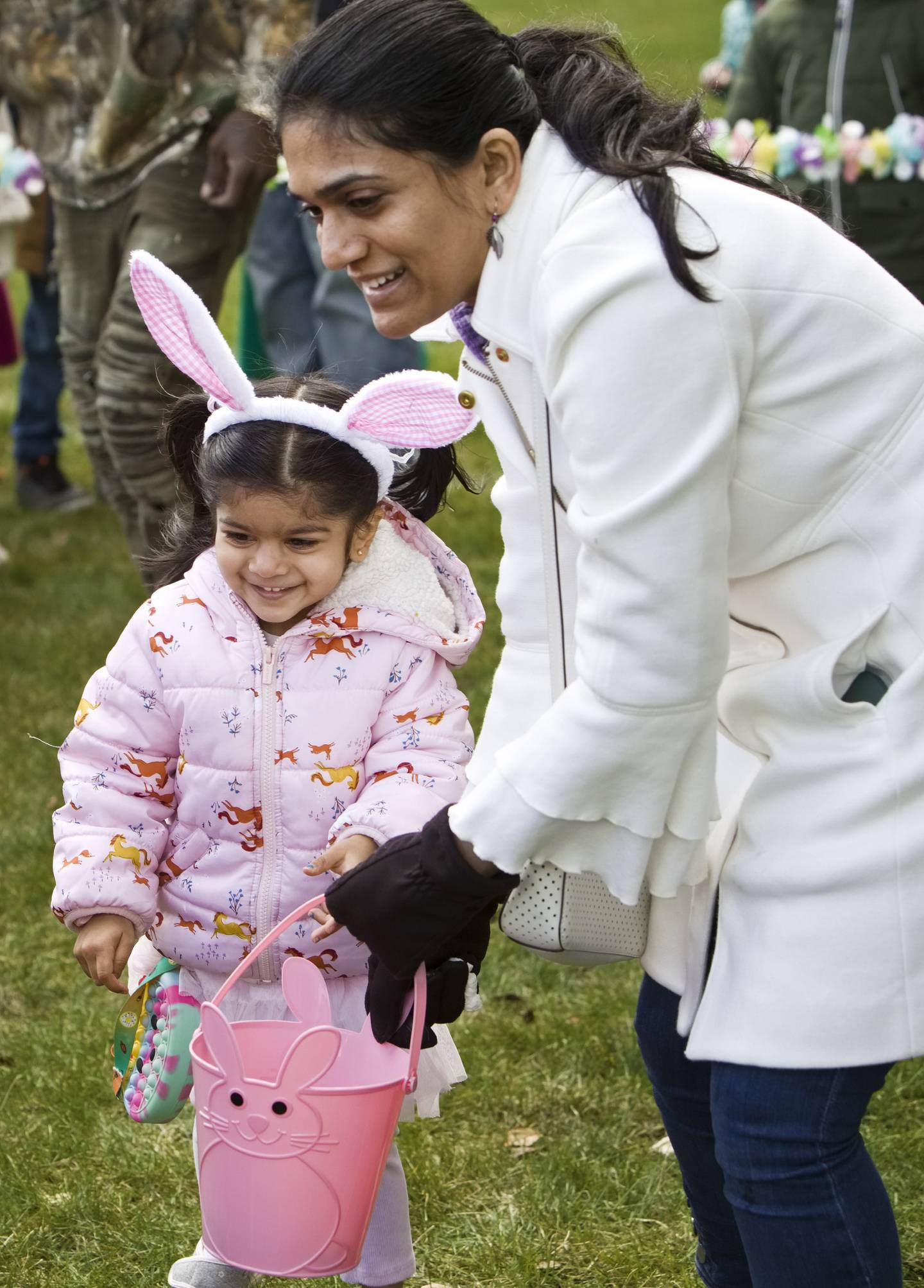 Krishna Patel helps her daughter Anya, 3, pick up candy filled eggs during Timbers of Shorewood Hippity-Hop Easter Egg Hunt Saturday, March 23, 2024, in Shorewood, Ill.