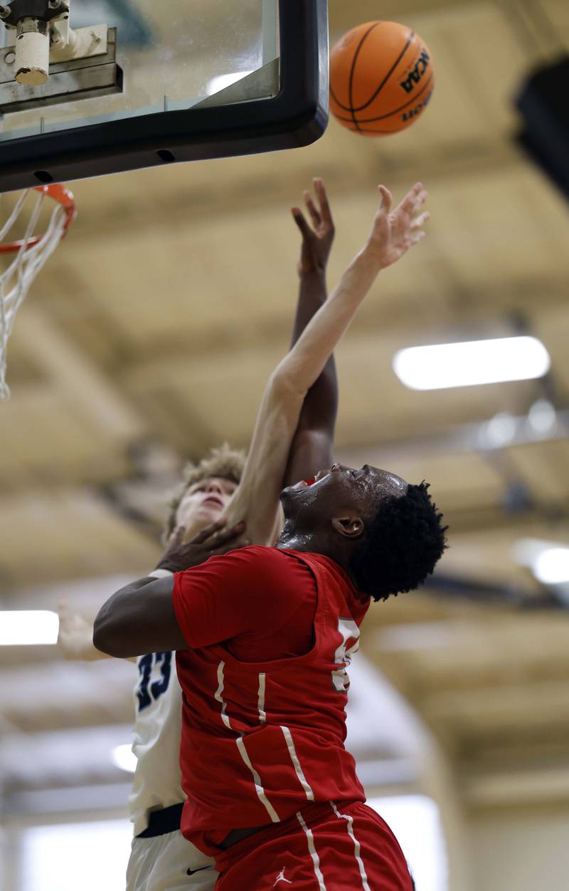 Palatine’s Tony Balanganayi (50) is fouled by Downers Grove South’s Erik Vagonis (33) on his way to the hoop during the Jack Tosh Holiday Tournament Thursday, Dec. 26, 2024 at York High School in Elmhurst.