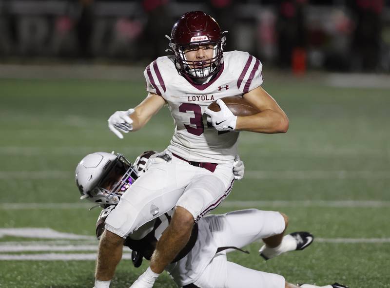 Loyola's Drew MacPherson (34) breaks free from the Mt. Carmel defense during the varsity football game between Loyola Academy and Mt. Carmel high school on Friday, Oct. 25, 2024 in Chicago.
