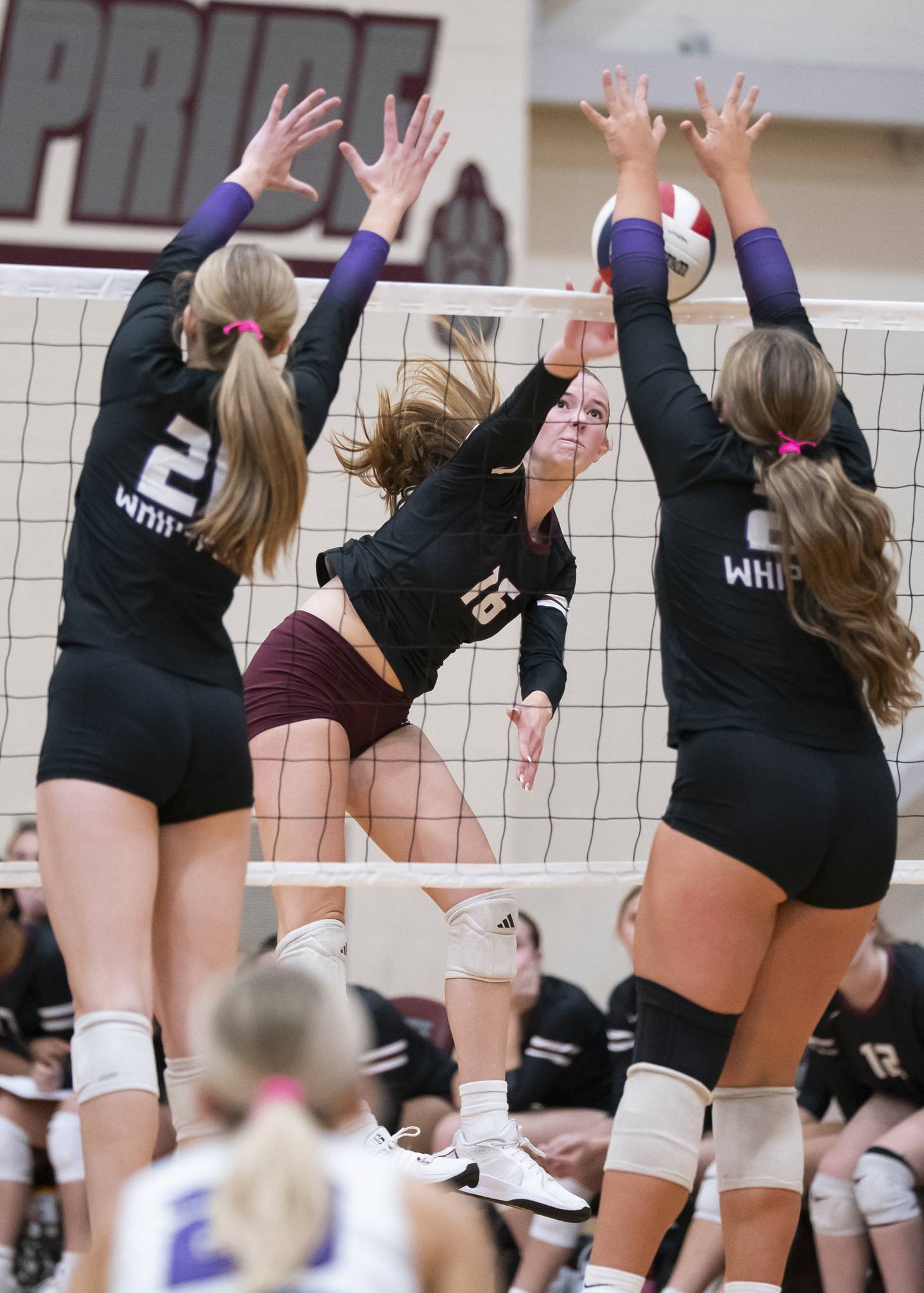 Prairie Ridge's Addy Grider spikes the ball in between Hampshire's Anna Schiltz, left, and Hailey Homola during their game on Thursday, October 2, 2025 at Prairie Ridge High School in Crystal Lake. Ryan Rayburn for Shaw Local