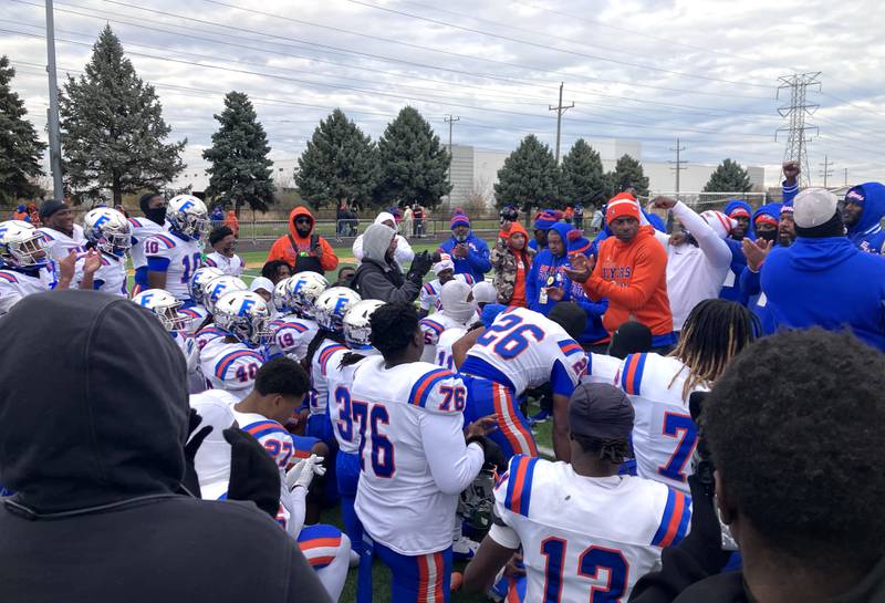 East St. Louis players celebrate along with coach Darren Sunkett after beating St. Laurence 50-7 Saturday, Nov. 22, 2025, in Burbank.