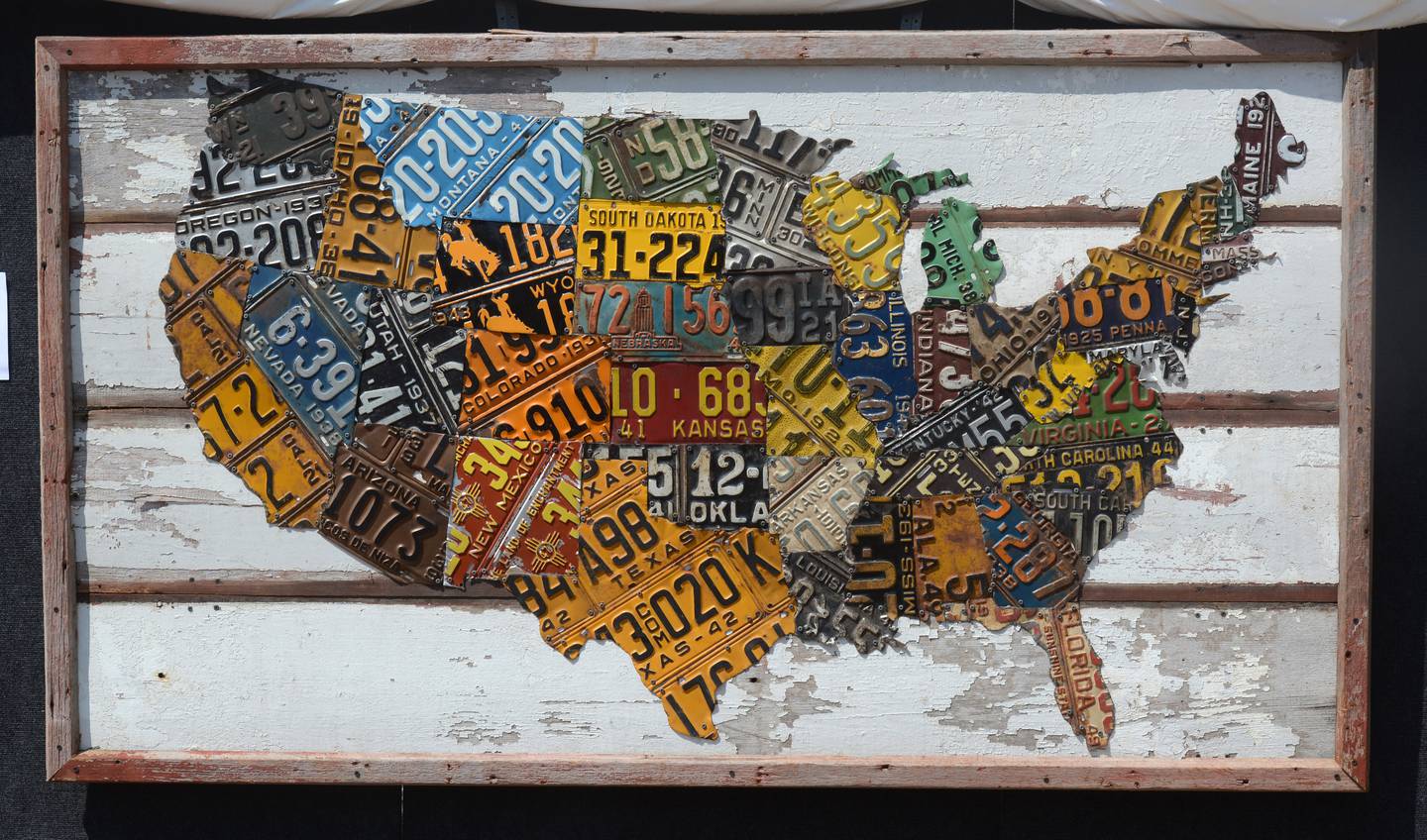 Created by artist Derek Christensen of Chicago, a U.S. map made of portions of license plates from the respective states is displayed during the Geneva Arts Fair on South Third St. in Geneva Saturday, July 23, 2022.