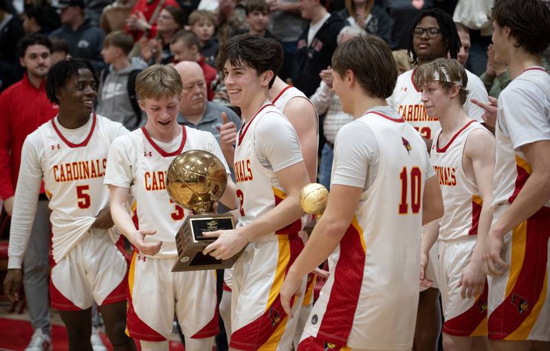 St. Anne's Matthew Langellier, center, holds the RVC Championship trophy surrounded by teammates after defeating Clifton Central in the RVC Tournament Championship on Friday, Feb. 13, 2026.