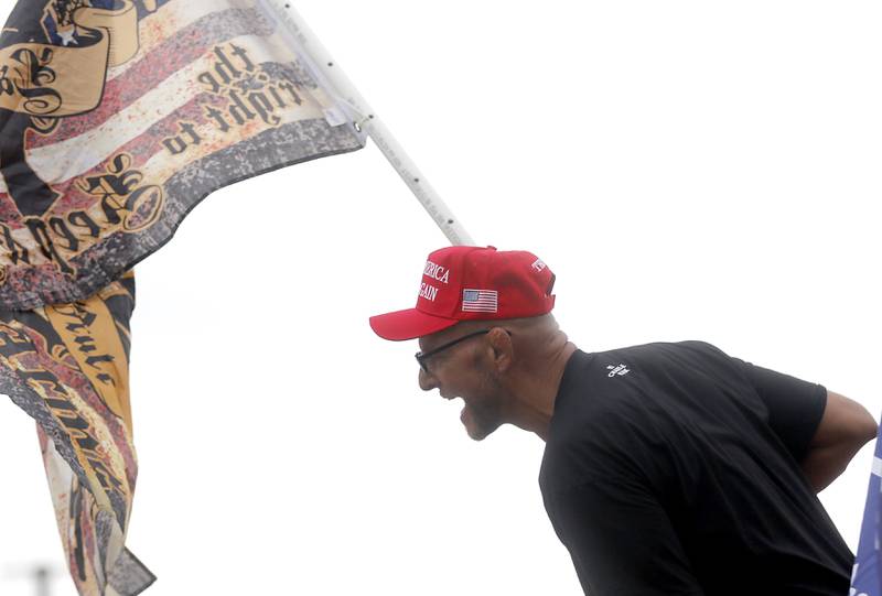 A Trump supporter yells as a protester from the bed of a pickup truck during a "No Kings” protest rally on Saturday, Oct. 18, 2025, along Route 31 in McHenry. The protest drew thousands of protesters to the area to protest the policies of President Donald Trump.