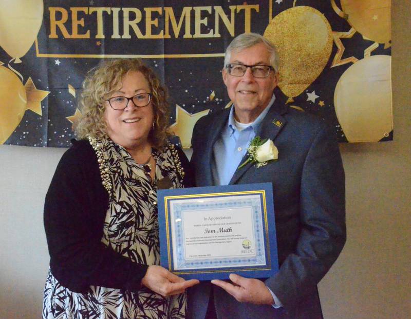 Tom Muth receives an an appreciation certificate Friday, Dec. 2, from Charlene Coulombe, executive director, Montgomery Economic Development Corp. Muth received the award at a  retirement open house after 36 years at Oswego's Fox Metro Water Reclamation District.