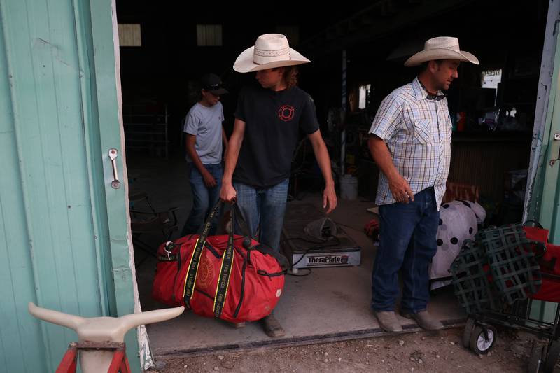 Dominic Dubberstine-Ellerbrock, left, carries his riding gear after practice. Dominic will be competing in the 2022 National High School Finals Rodeo Bull Riding event on July 17th through the 23rd in Wyoming. Thursday, June 30, 2022 in Grand Ridge.