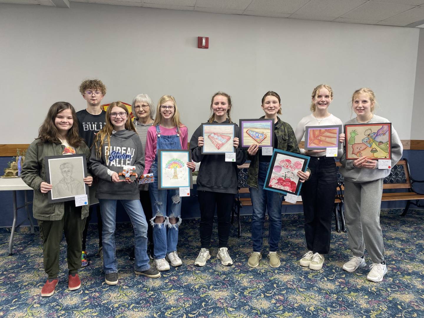 Individual honors went to Isabella van den Berg, first place in pencil portrait, and Julian Mucha, second place. Elise House and Annalise Baker received second and first places respectively for their 3-D Miscellaneous projects, and Annalise also received second place for her collage. In the 2-D section for colored pencil, Isla Bayer received third place, Leah House received first, Karlie Schultz received Honorable Mention, and Alice Scruggs received second place. Art teacher Lane House is also pictured.