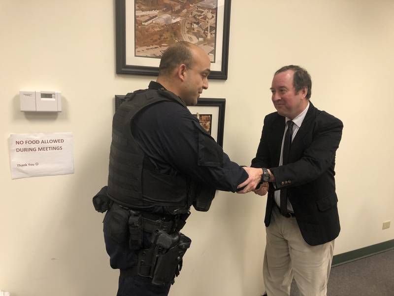 Ramtin Sabet, left, is congratulated by Hebron Village Attorney Michael Smoron following Sabet's swearing in as the village's new chief of police on Dec. 27, 2022.