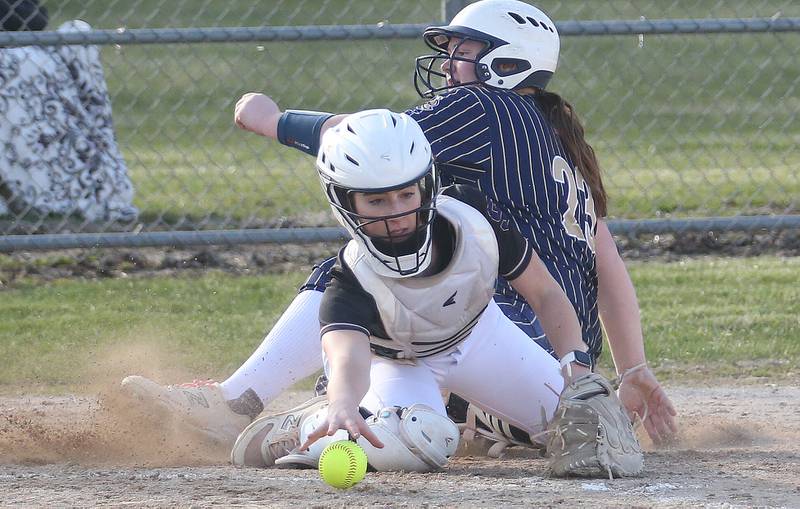 Marquette's Taylor Cuchra slides safely into home as Serena catcher RayElle Brennan reaches out to bare-hand the late throw to the plate on Wednesday, March 26, 2025 at Serena High School.