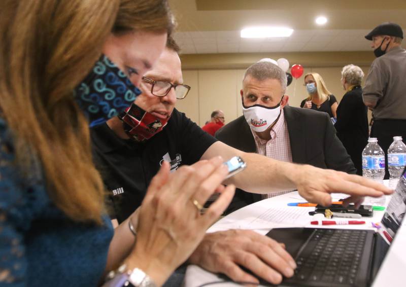 DeKalb mayoral candidate Cohen Barnes (right) checks the computer for results with his wife Amy and Faranda's owner Bill McMahon Tuesday as returns begin to come in during an election night party at Faranda's Banquet Center in DeKalb.