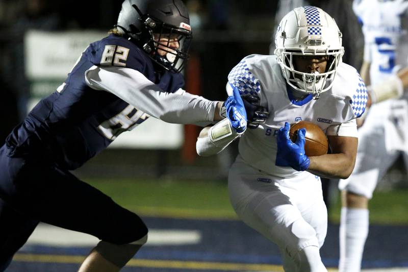 St. Francis’s Terreon Roundy (right) tries to get away from IC Catholic Prep’s Ryan Vezza during their football game at Plunkett Park in Elmhurst, Ill., on Friday, March 19, 2021.