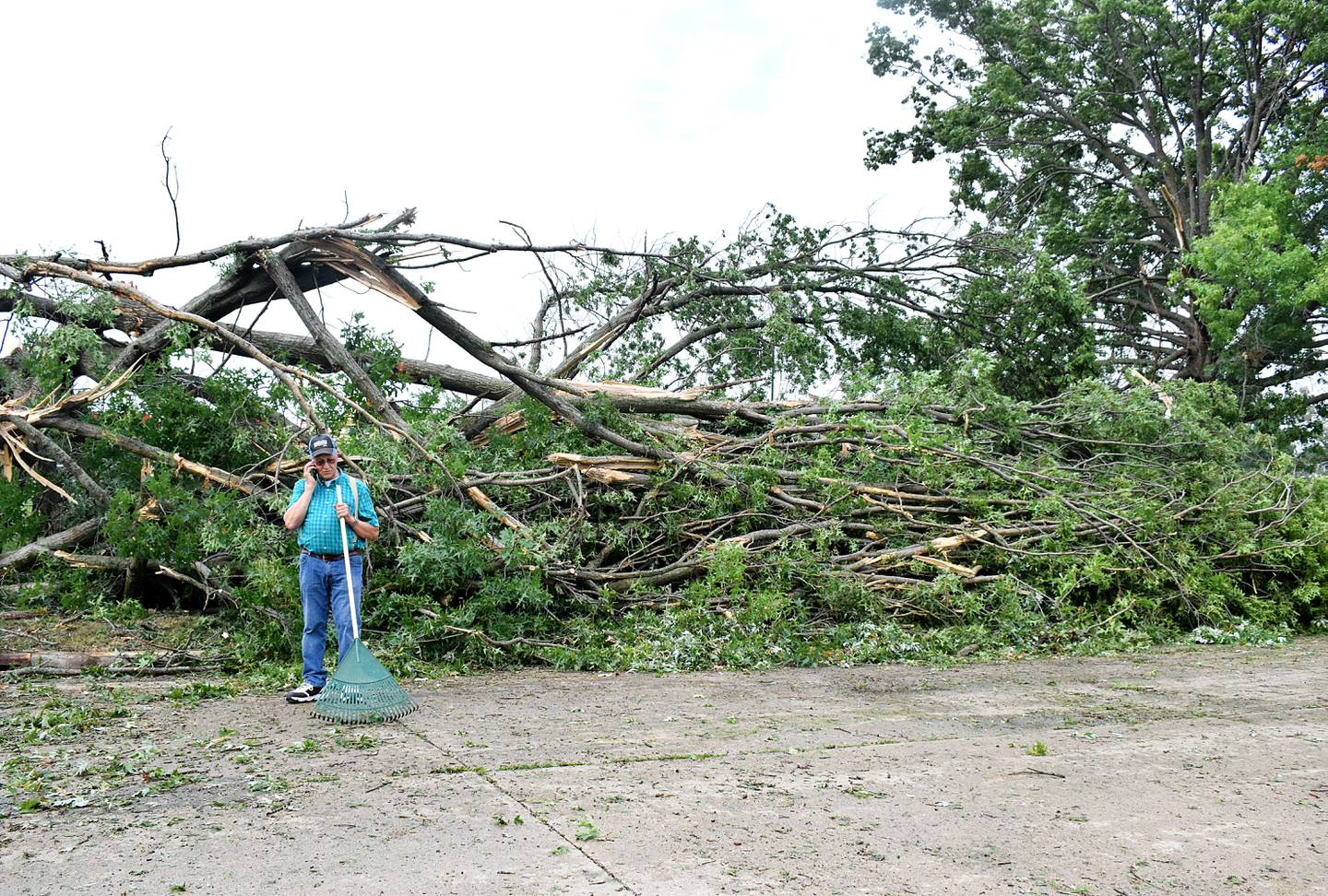Paul Kool, of Newton, speaks on the phone while raking up debris from the August 2020 derecho. Residents of Jasper County are encouraged to provide input, ask questions or give suggested revisions to the newly updated hazard mitigation plan.