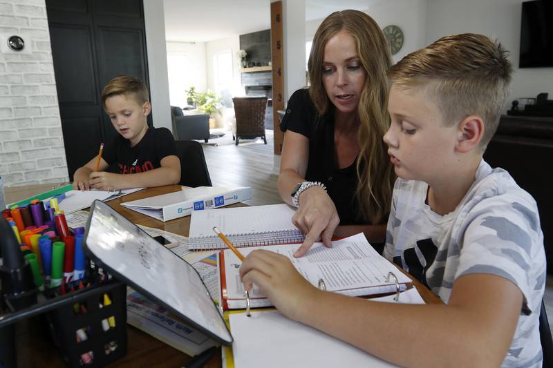 Jessica Clements helps her sons Gavin, 7, left, and Myles, 10, during a homeschool session with learning materials from The Good and The Beautiful at home on Tuesday, Aug. 17, 2021 in McHenry.  This is the family's first time trying home schooling.  Myles is in 5th grade, Gavin is in 2nd, and Dayne, 4, is in preschool.