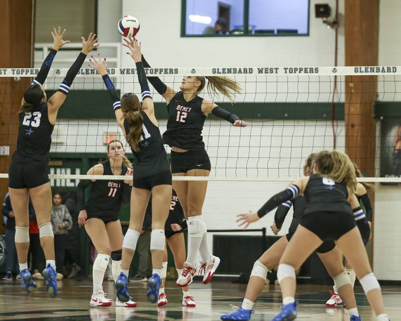 Benet's Carolyn Tarnow (12) tips the ball over the net during Class 4A Glenbard West Sectional final volleyball match between St Charles North at Benet. Nov 6, 2025 in Glen Ellyn.