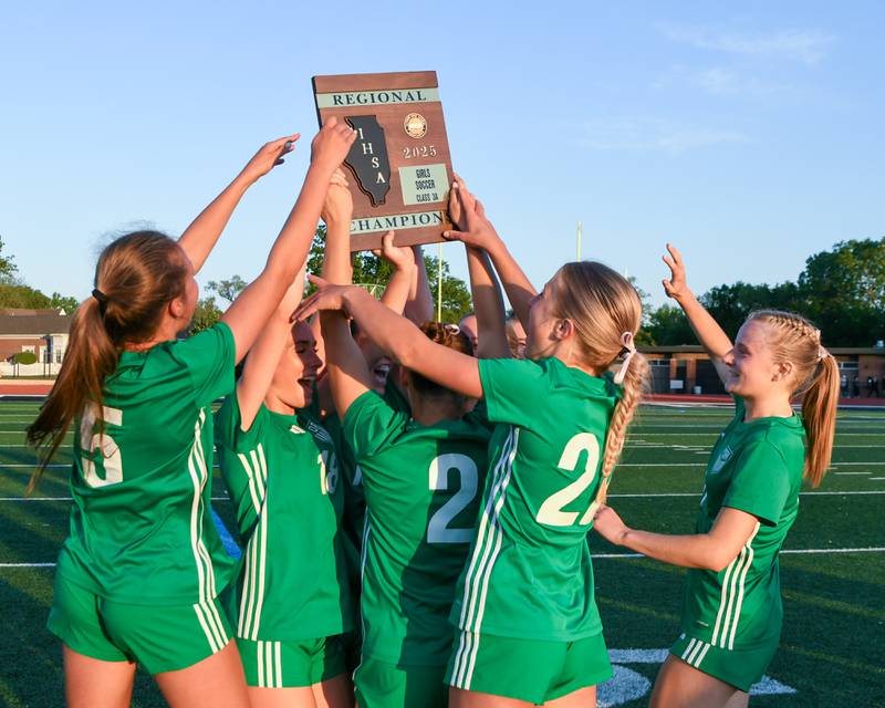 Some of York High School ‘s soccer team celebrate with the regional championship plaque after defeating Downers Grove South in the regional title game on Friday May 23, 2025, held at York High School.