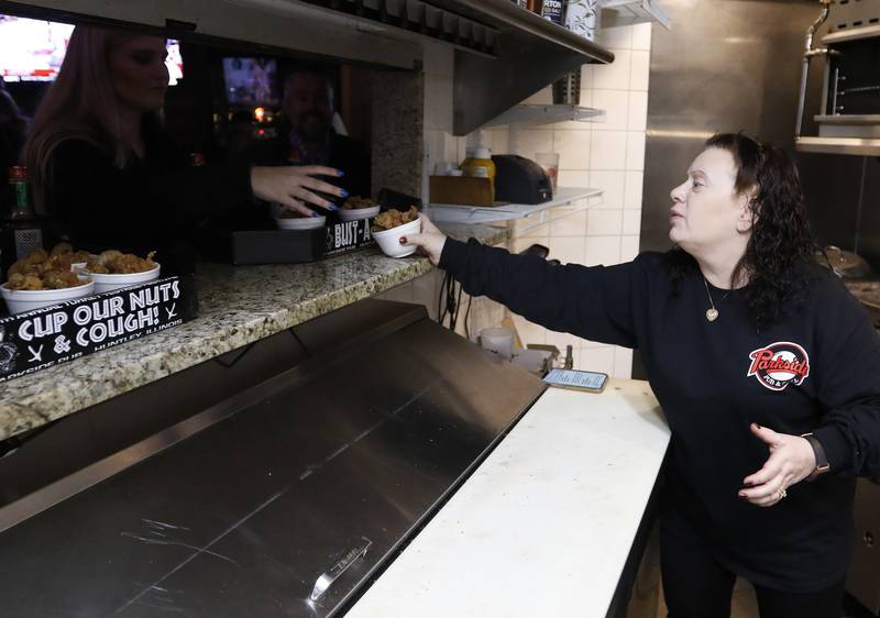 Nancy Rubino hands off a basket of fried turkey testicles fresh from the kitchen during the 39th annual Turkey Testicle Festival at Parkside Pub on Wednesday, Nov. 24, 2021, in Huntley.