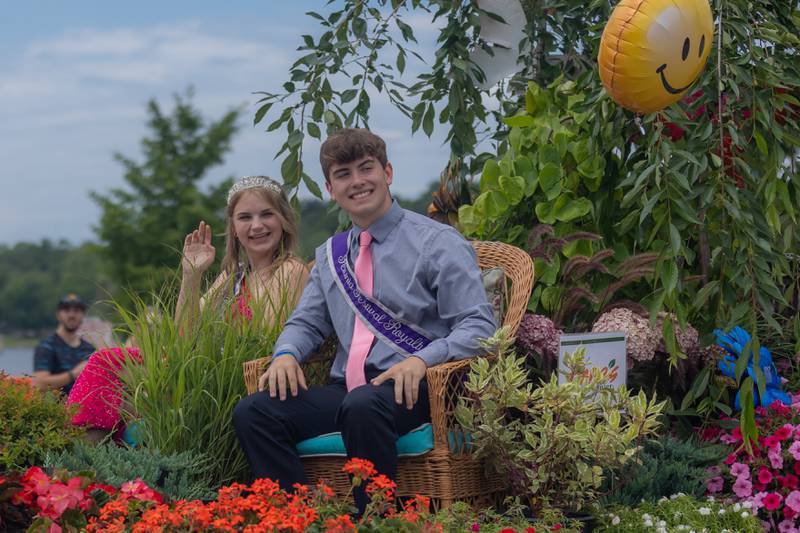 Petunia Festival attendants Elyse Stevens and Owen Winters wave as they pass by during the parade Sunday, July 7, 2024.