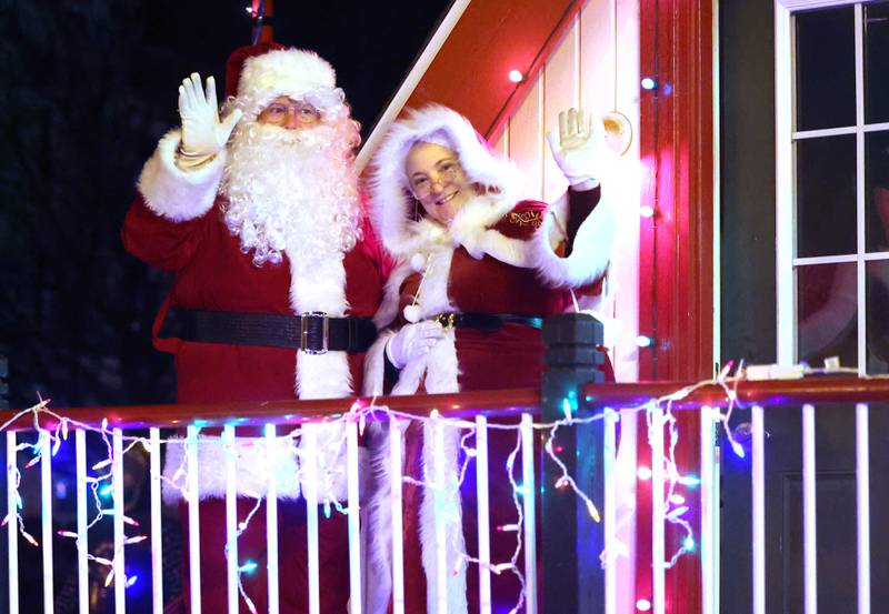Santa and Mrs Claus wave to their fans as they get ready to head into his house at the corner of West State and North Maple Streets Friday, Dec. 6, 2024, during the Sycamore Chamber of Commerce’s Walk With Santa in downtown Sycamore.